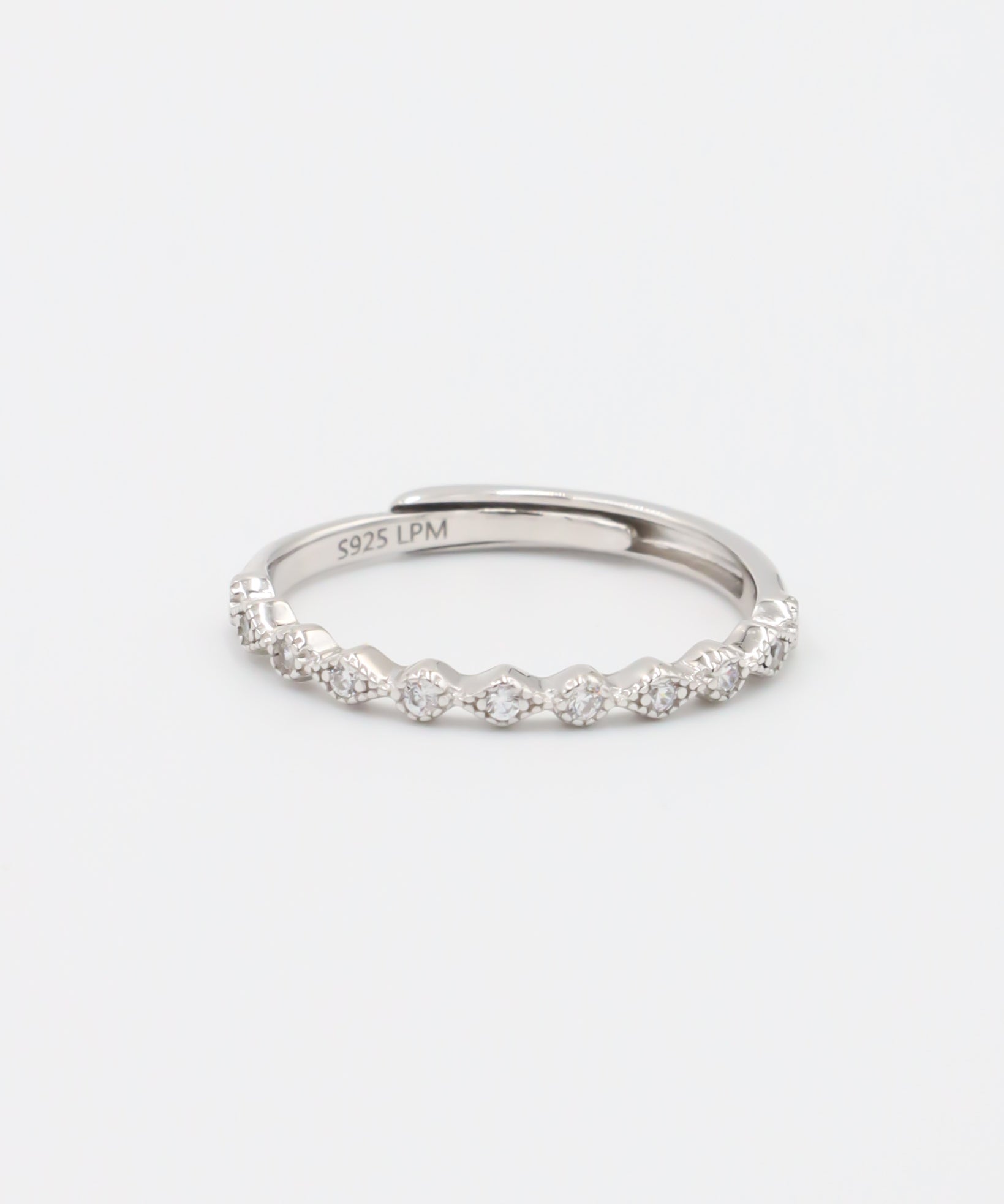 A silver ring with multiple gemstones set around its circumference, displayed against a white background.