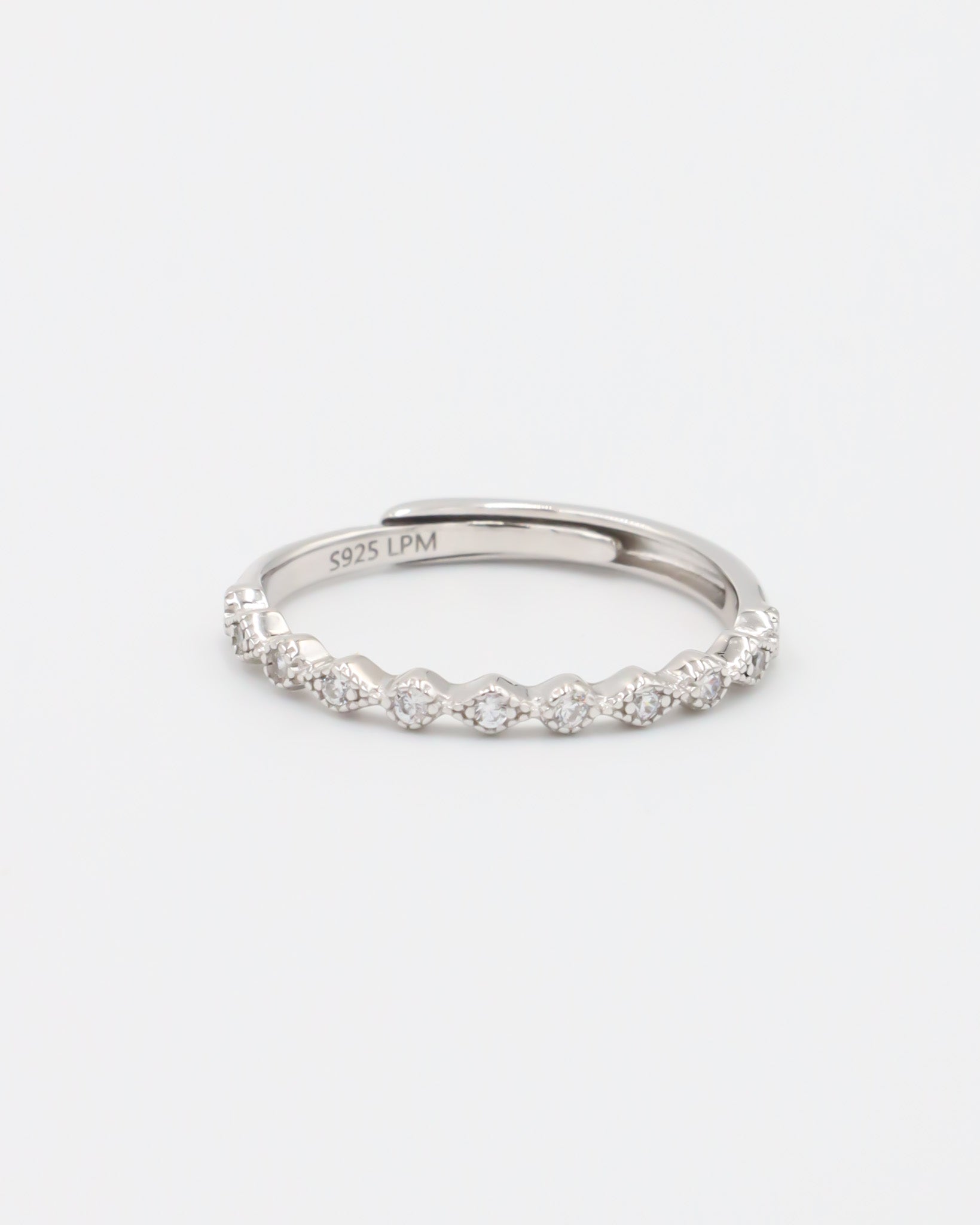 A silver ring with multiple gemstones set around its circumference, displayed against a white background.