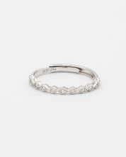 A silver ring with multiple gemstones set around its circumference, displayed against a white background.