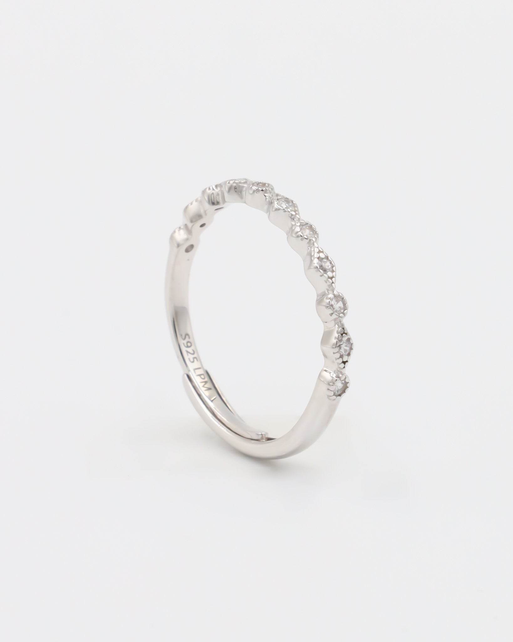 A silver ring with multiple gemstones set around its circumference, displayed against a white background.