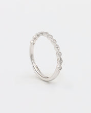 A silver ring with multiple gemstones set around its circumference, displayed against a white background.