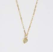 A gold-colored necklace with a heart-shaped pendant on a chain.