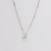 A silver necklace with a small charm pendant, displayed against a white background.