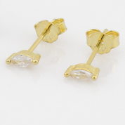 Gold earrings with clear gemstones on a white background