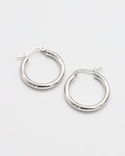 A pair of silver hoop earrings with a latch back closure on a white background