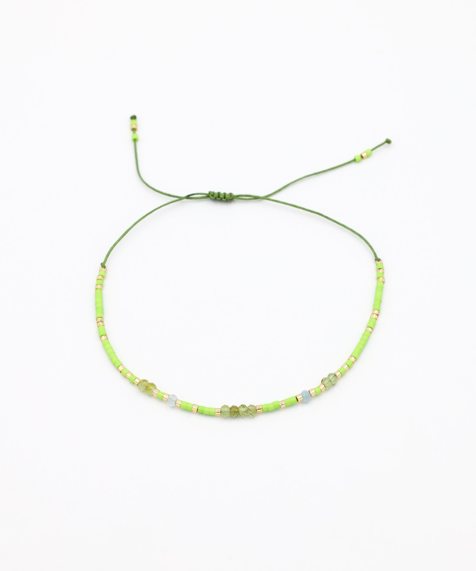 An adjustable beaded necklace with green and gold-colored beads and rhinestones on a white background.