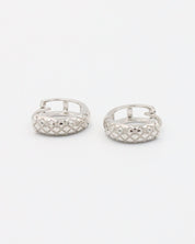 A single silver hoop earring with a geometric pattern and a hinged clasp.