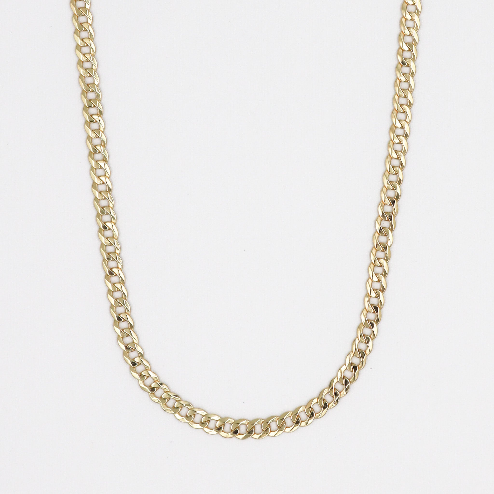 A gold-colored necklace with a curb chain link on a white background.