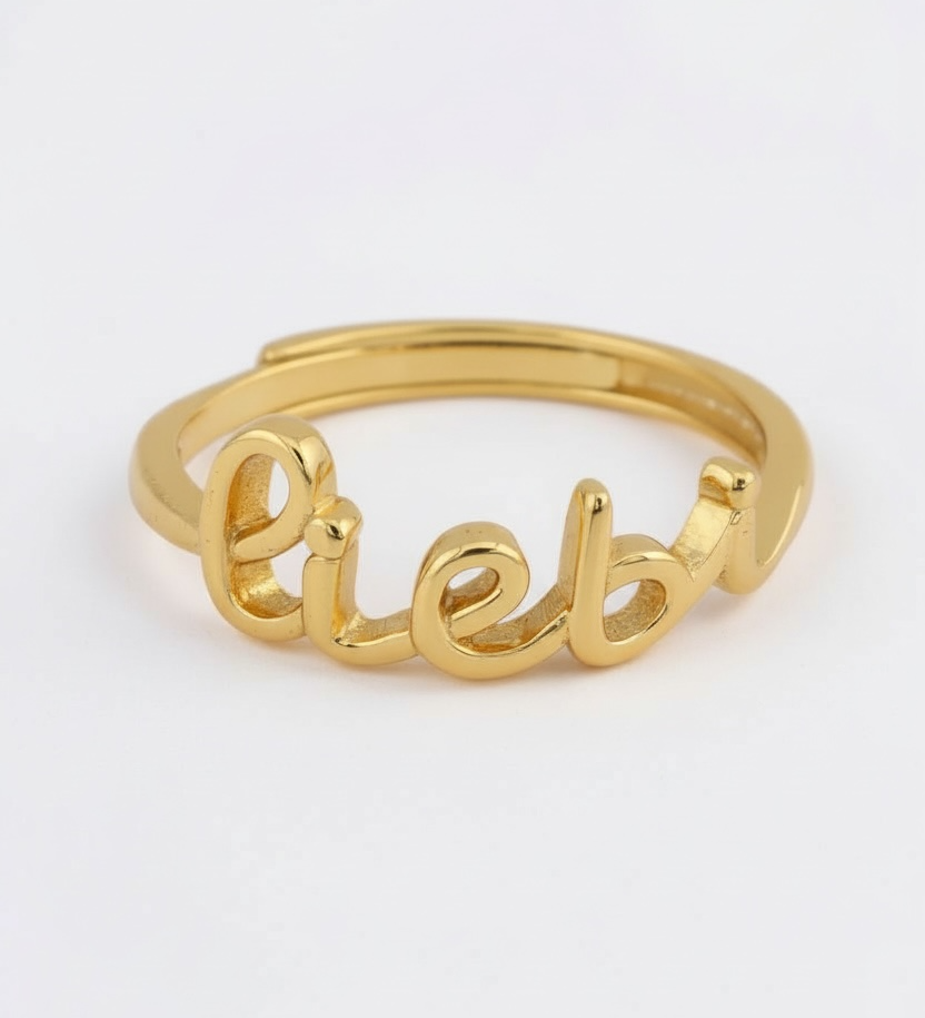 Gold ring with 'liebe' engraving on a white background