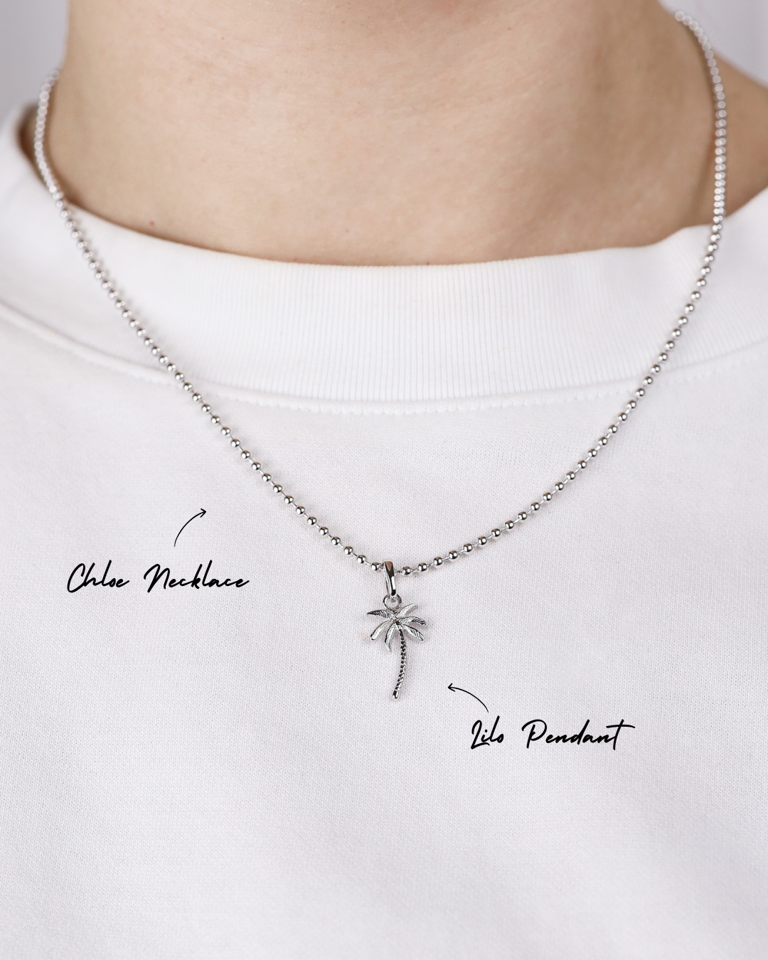Silver necklace with a palm tree pendant on a white background