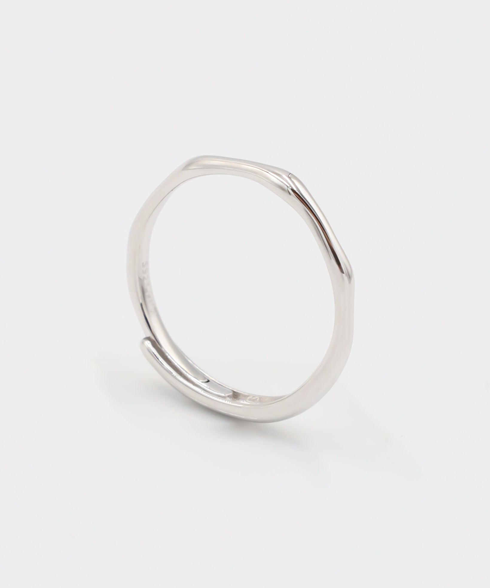 A silver ring standing on a white background.