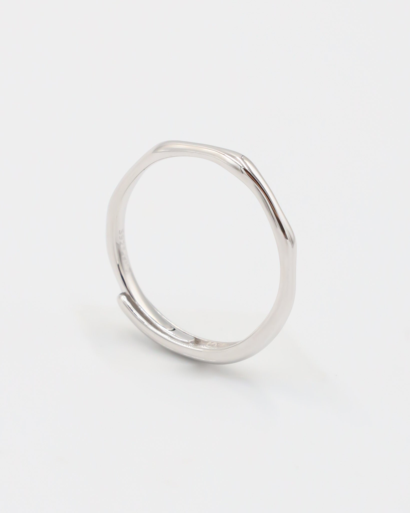 A silver ring standing on a white background.