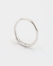 A silver ring standing on a white background.