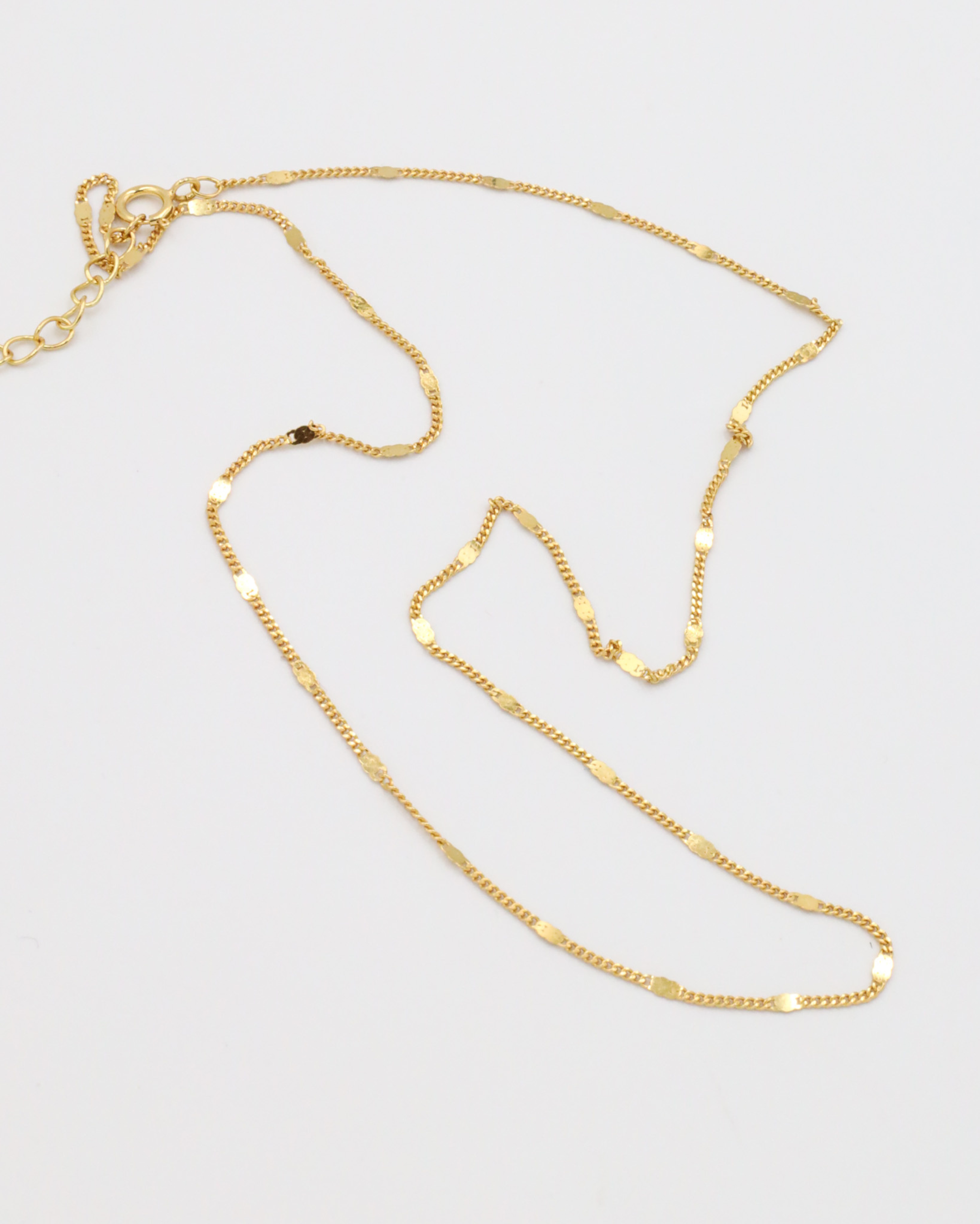 Loretta Necklace in gold-plated 925 sterling silver, laid out to show its dainty chain design.