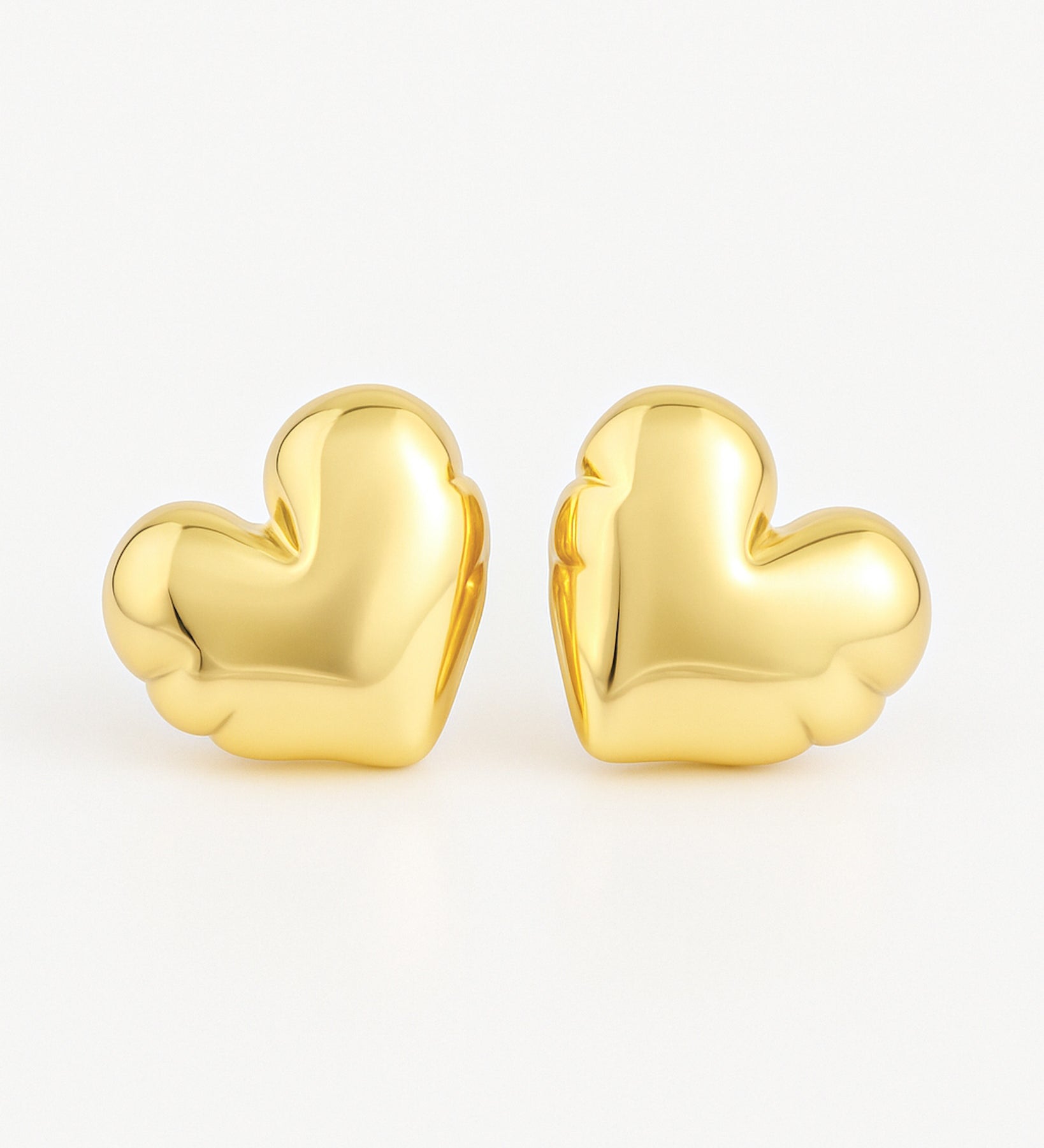 Gold heart-shaped earrings on a white background