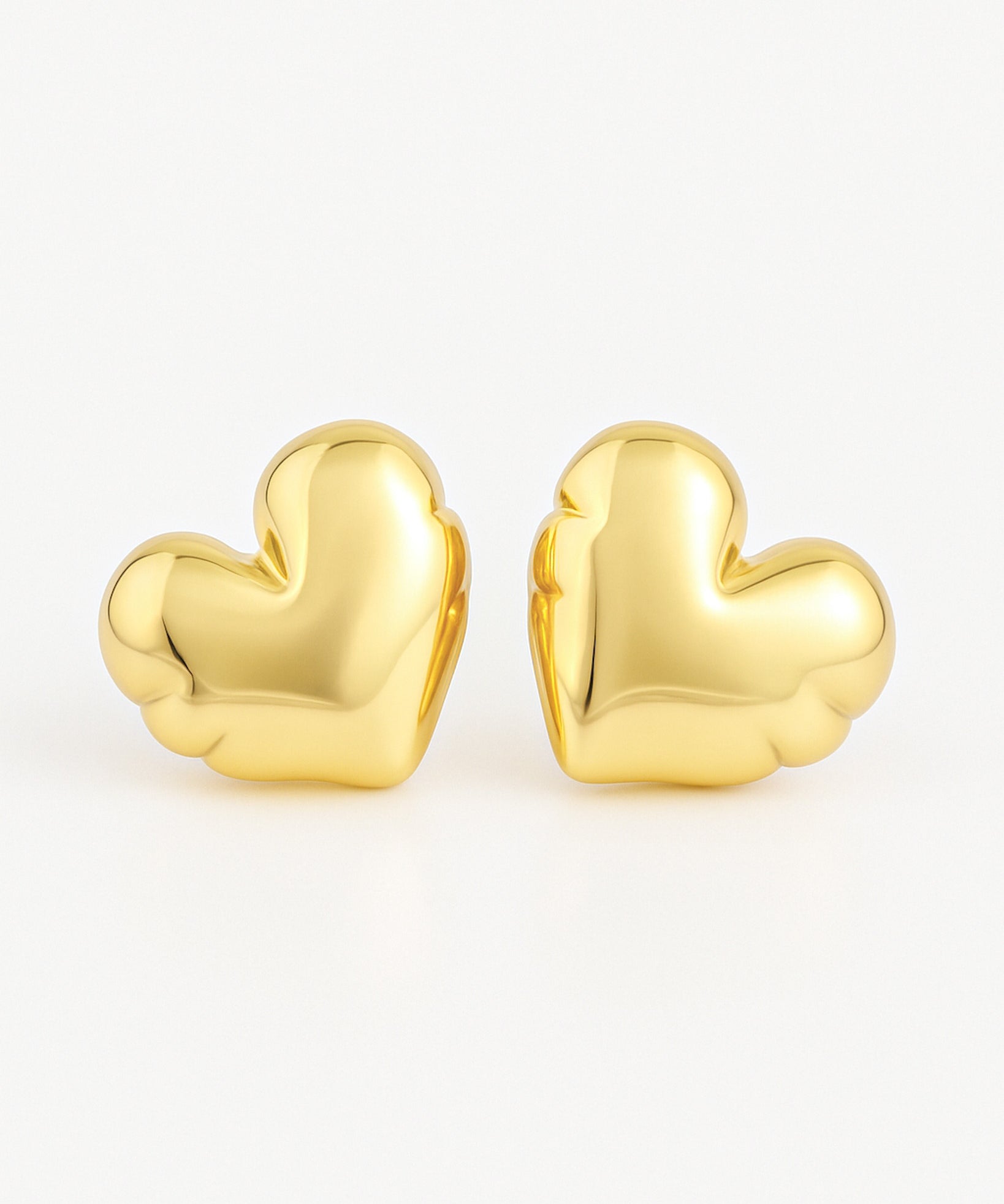 Gold heart-shaped earrings on a white background