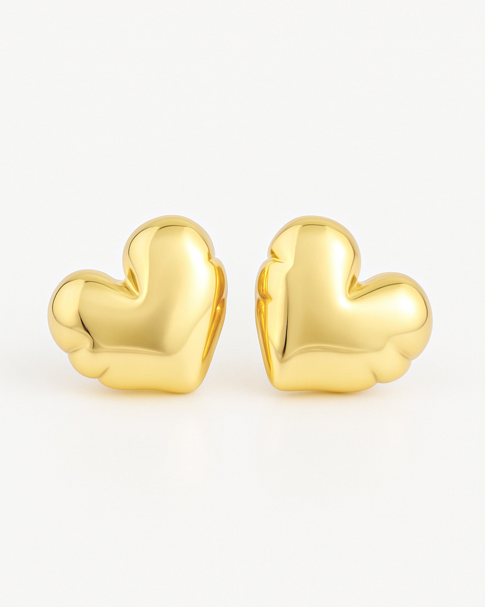Gold heart-shaped earrings on a white background