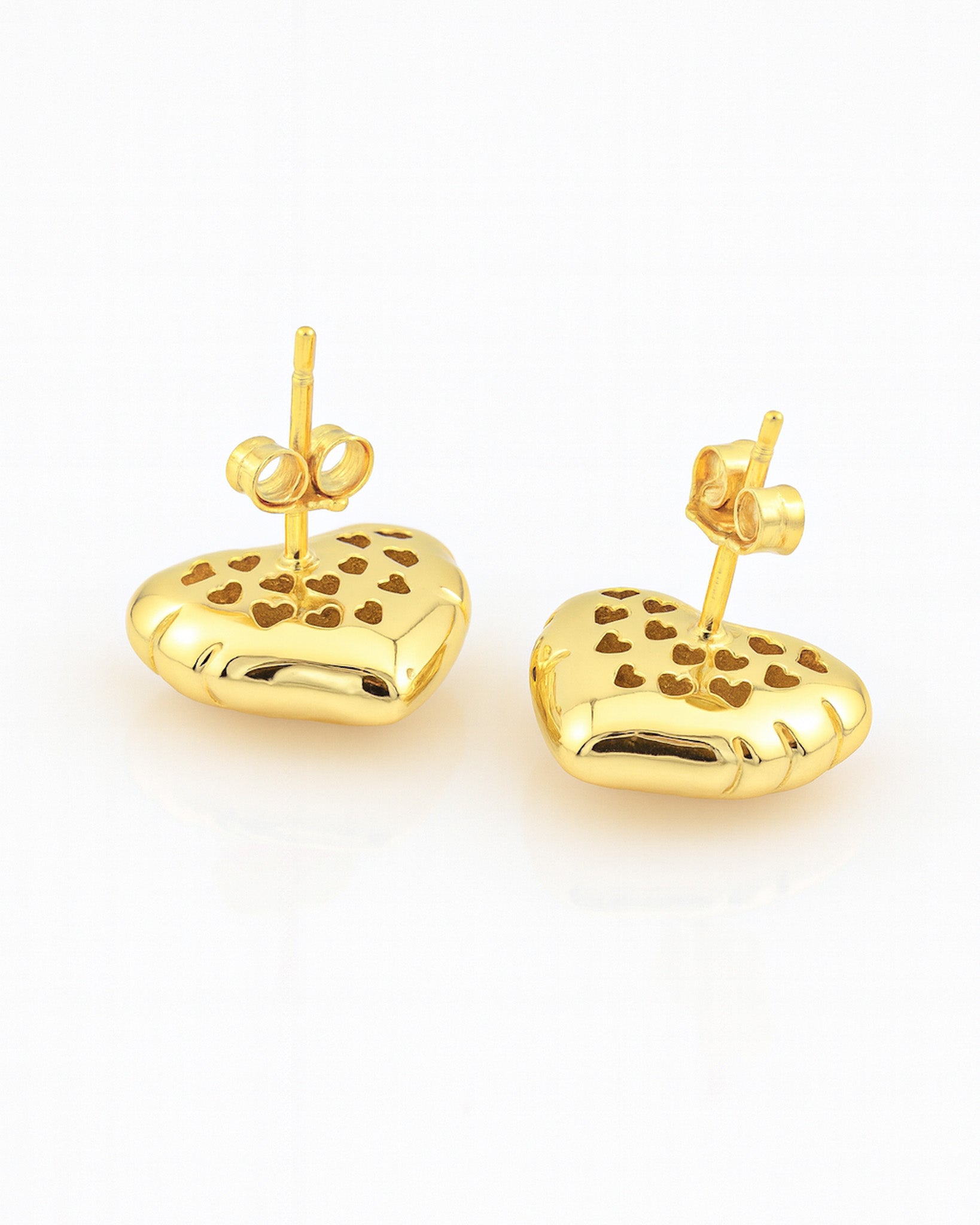 Gold heart-shaped earrings with cut-out designs on a white background