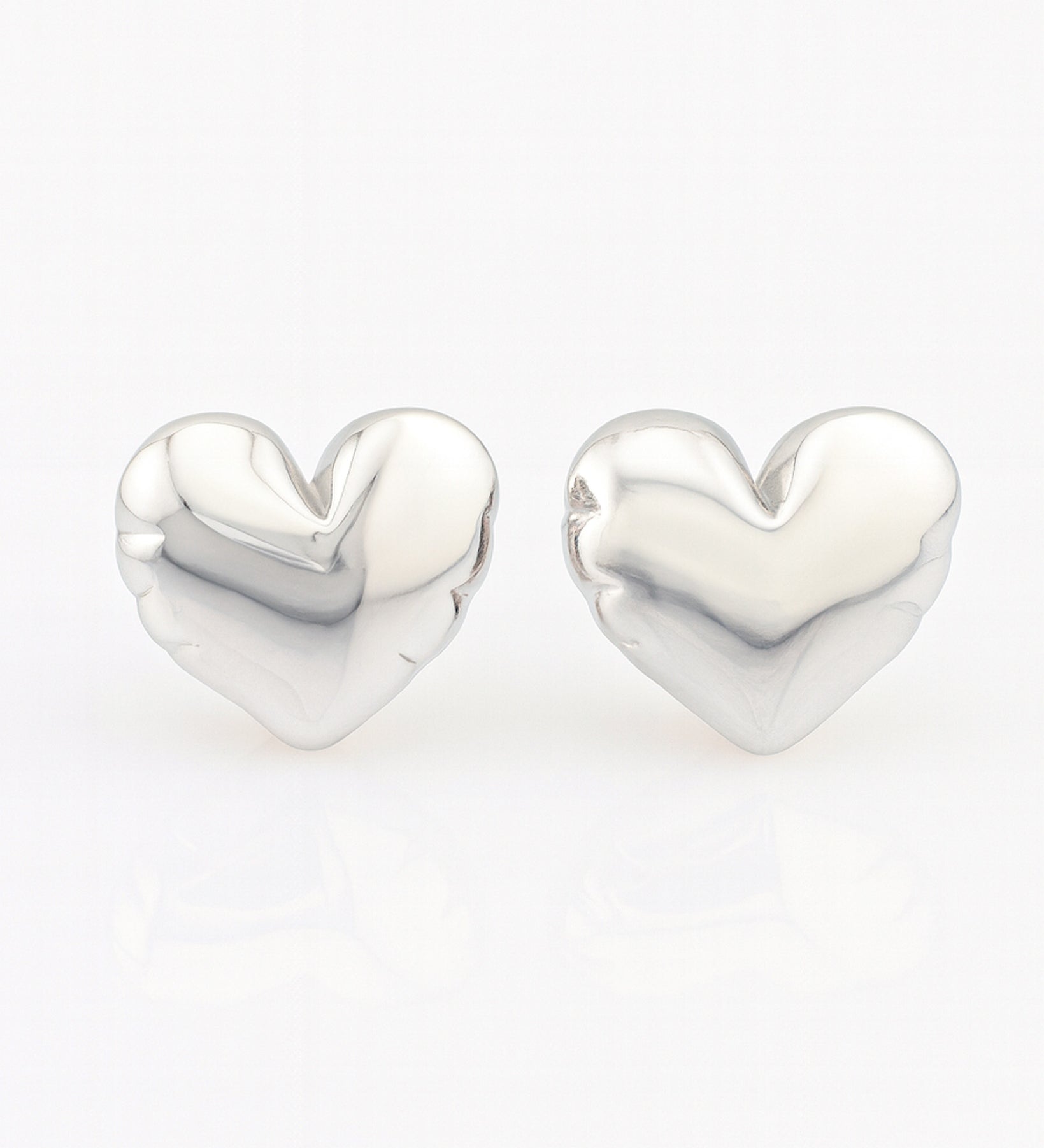 Heart-shaped silver earrings on a white background