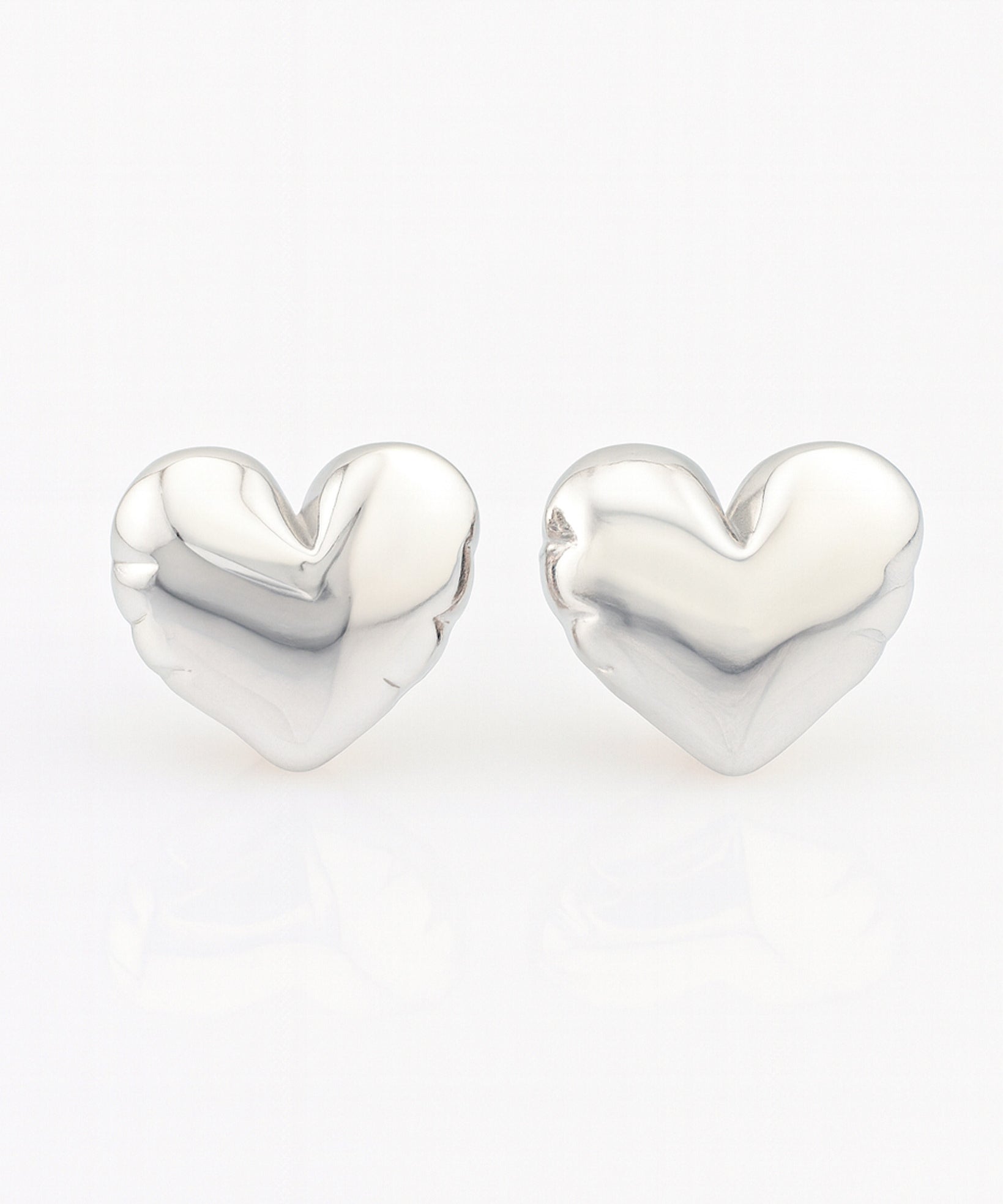 Heart-shaped silver earrings on a white background