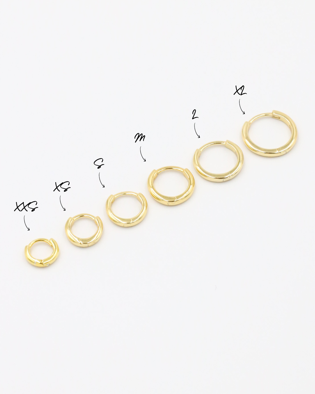 A series of circular gold colored hoops of varying sizes arranged in a line on a white background.