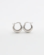A pair of silver hoop earrings with a latch back closure on a white background