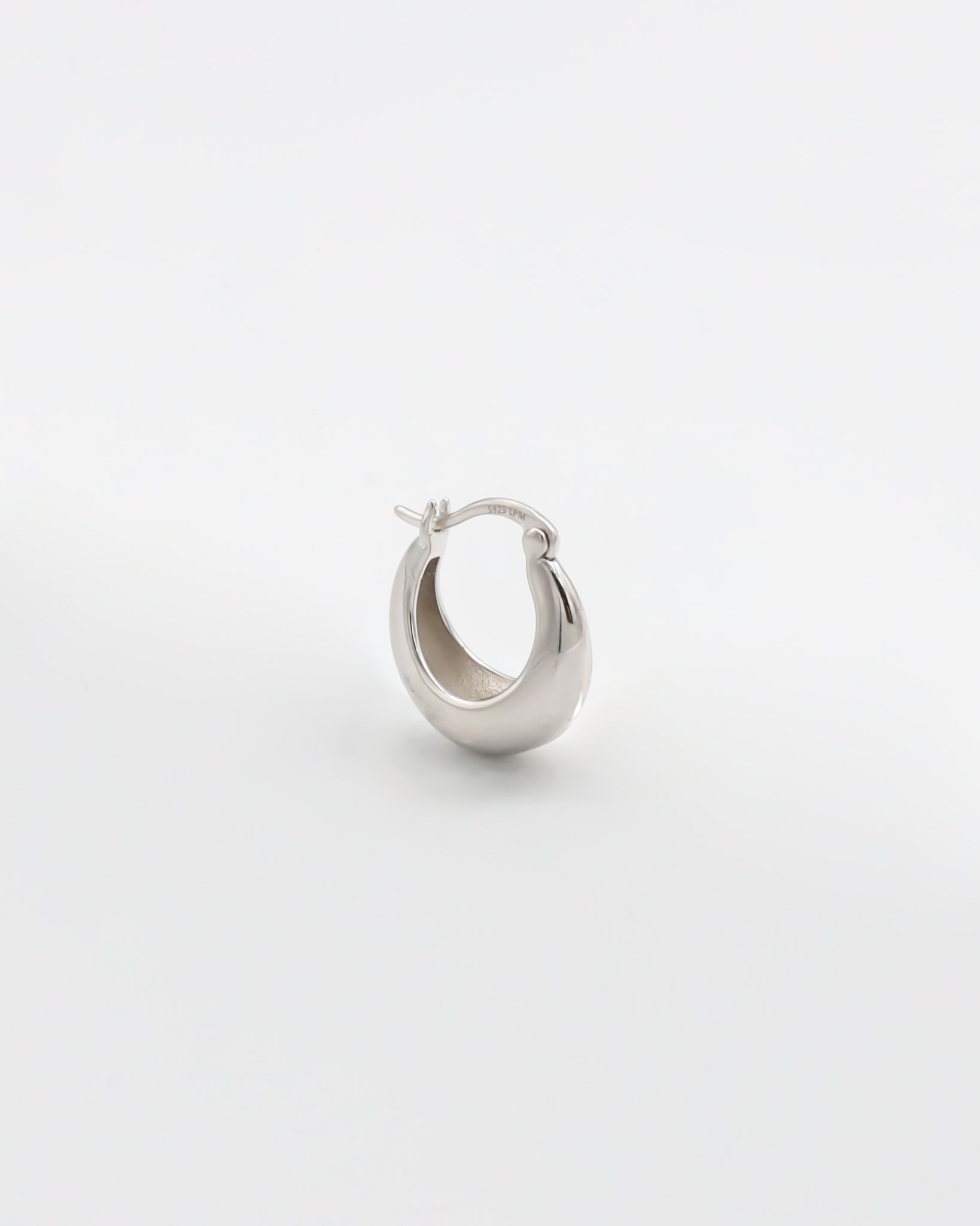 A single silver hoop earring with a latch back closure on a white background