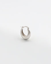 A single silver hoop earring with a latch back closure on a white background