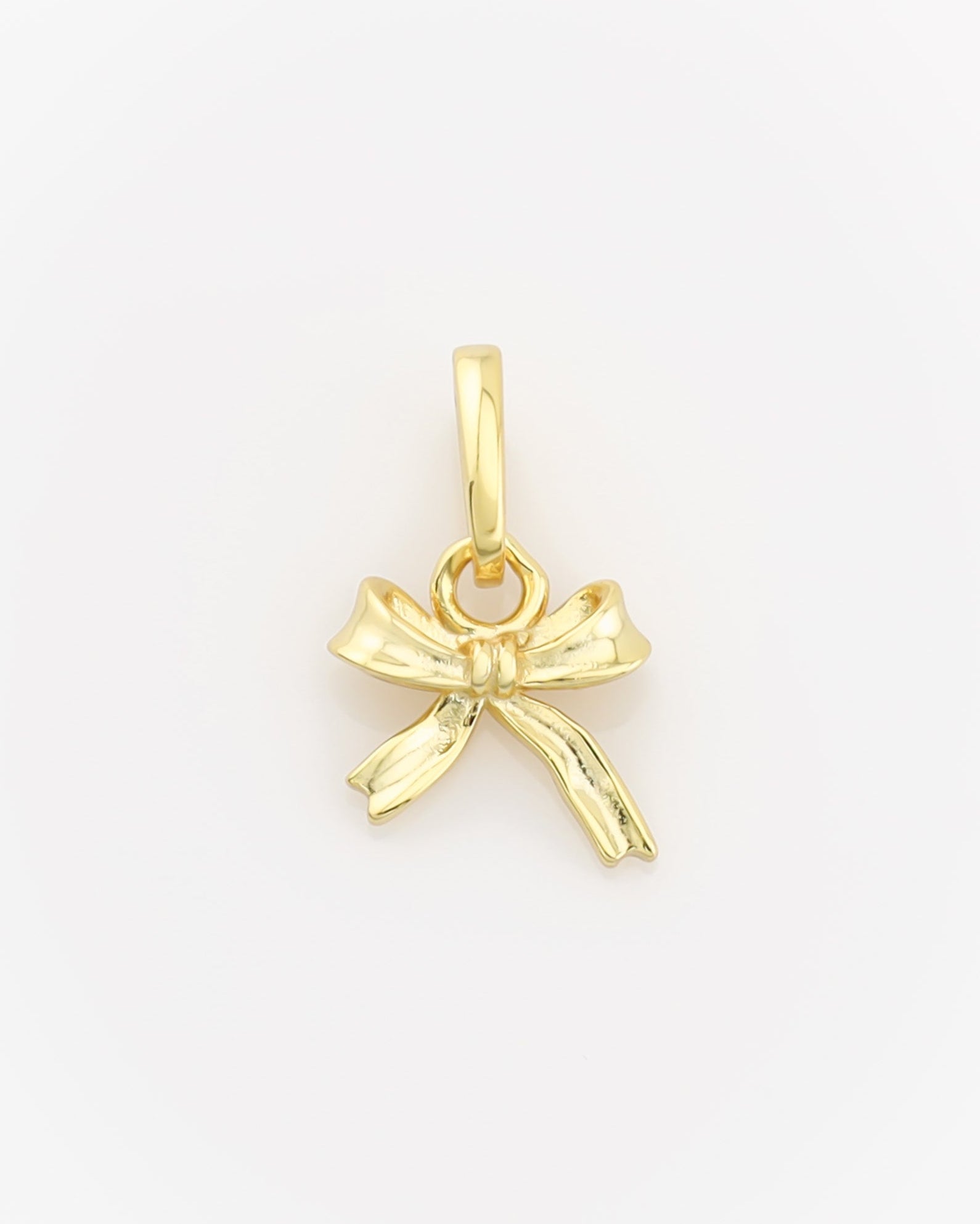 Gold bow-shaped pendant on a light gray background