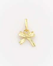 Gold bow-shaped pendant on a light gray background