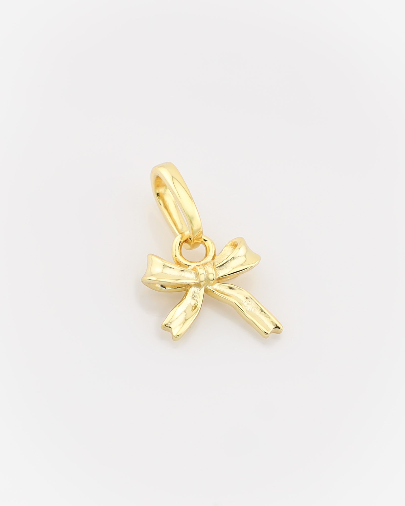Gold bow-shaped pendant on a light gray background