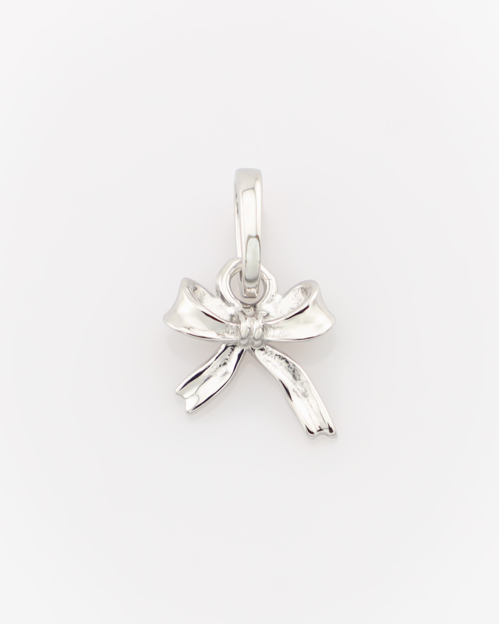 Silver bow-shaped pendant on a white background