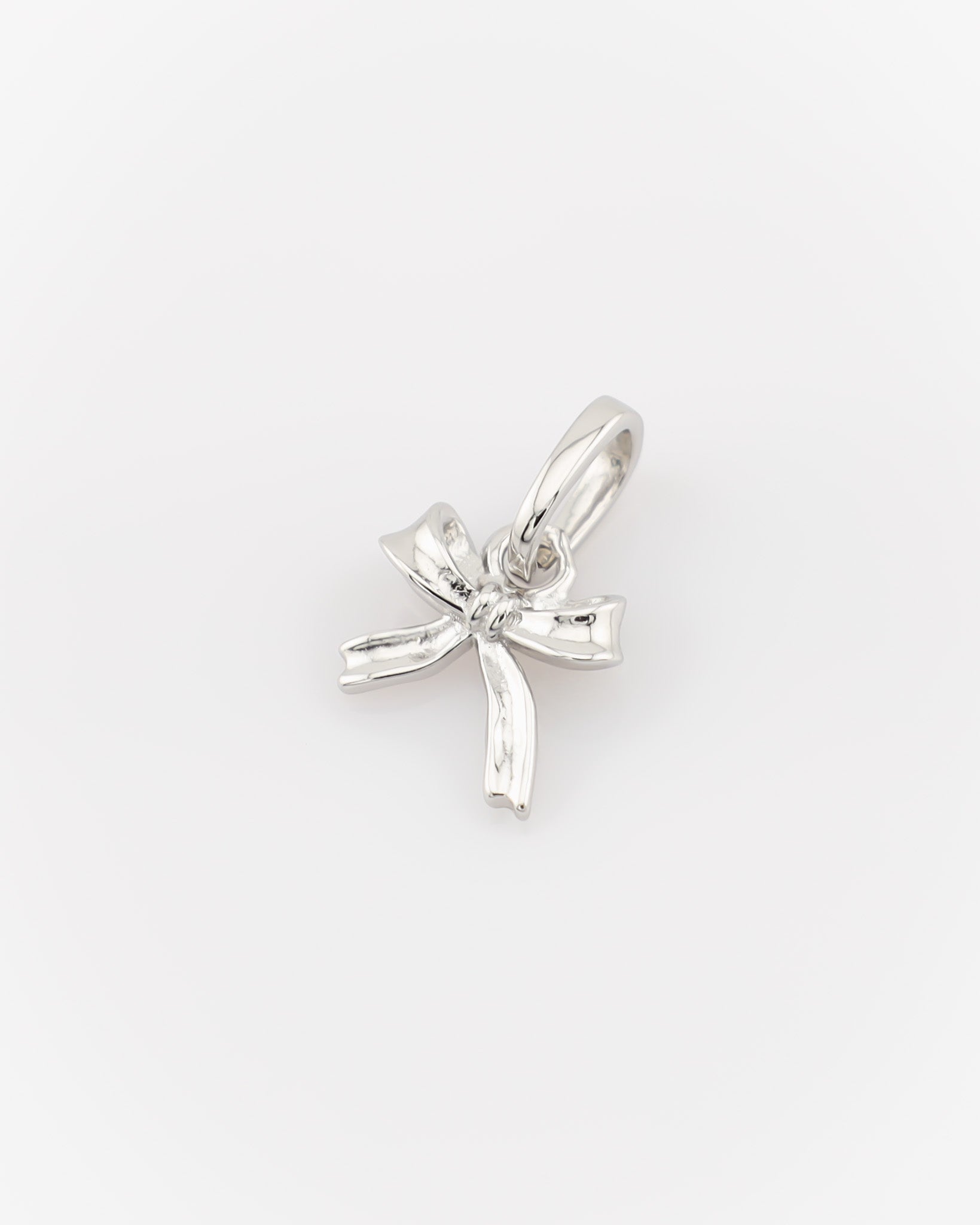 Silver bow-shaped pendant on a white background