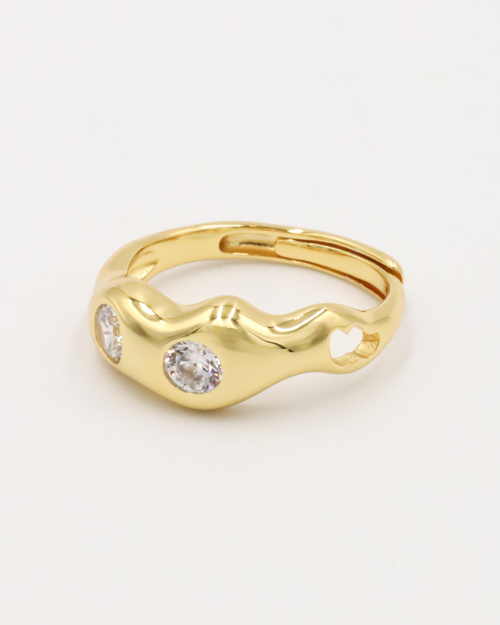 A gold-colored ring with two clear stones set in a wave-like design.