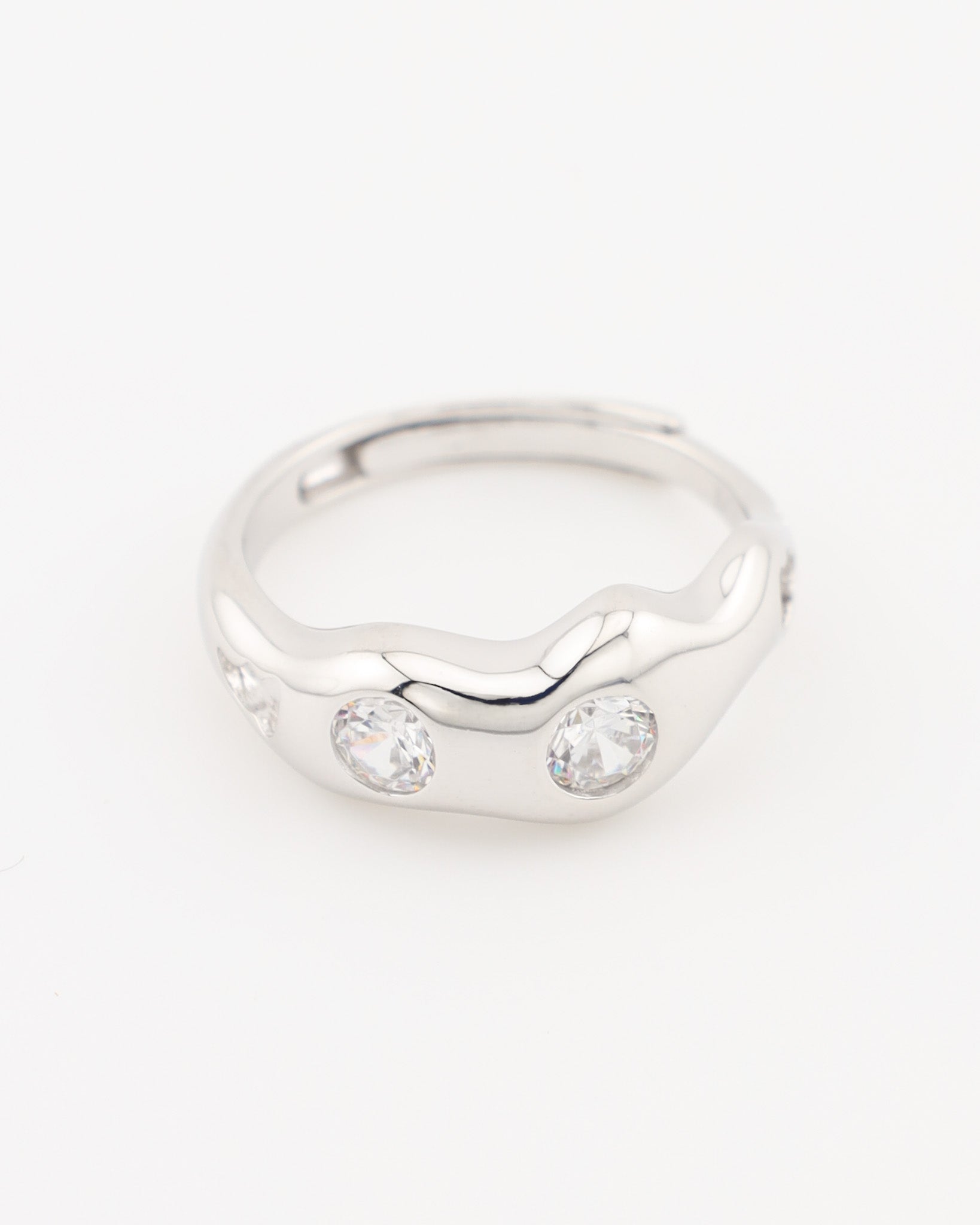 Silver ring with two clear gemstones on a white background