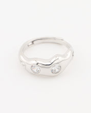 Silver ring with two clear gemstones on a white background