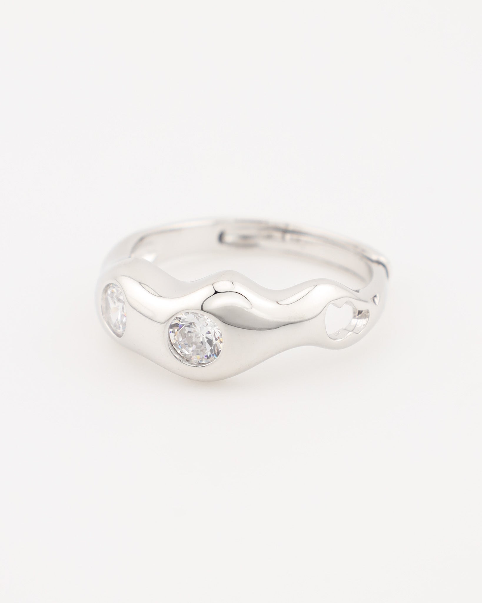 A silver-colored ring with two clear stones set in a wave-like design.