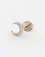 A single silver-colored earrings with a crescent shape and small, embedded stones, displayed against a white background.