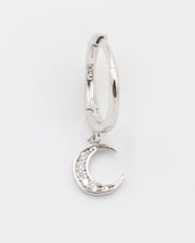 A silver hoop earring with a crescent moon charm attached, displayed against a white background.