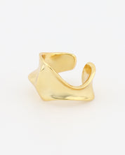 Gold Ear Cuff on a light beige background