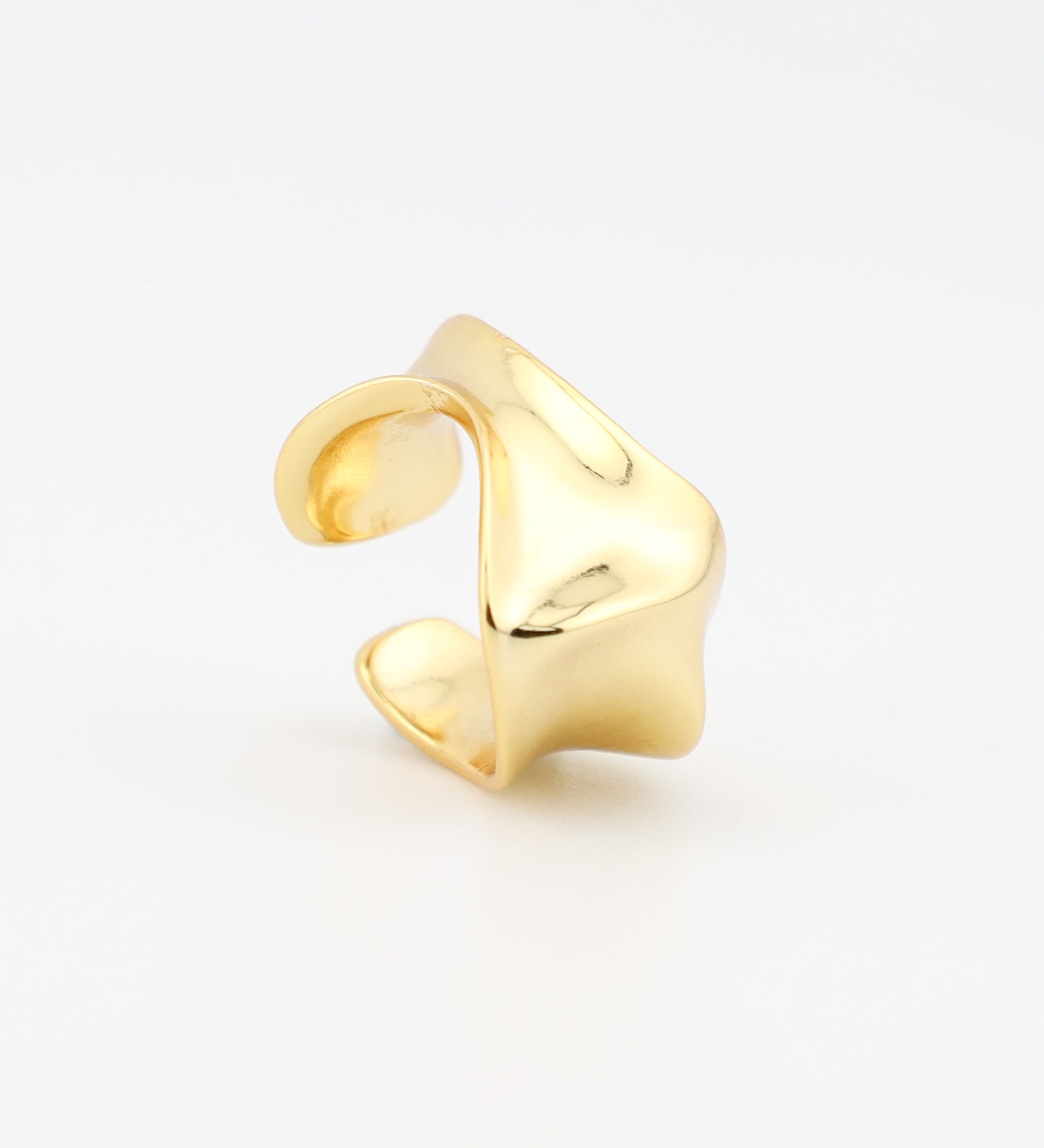 Gold ear cuff on a light gray background