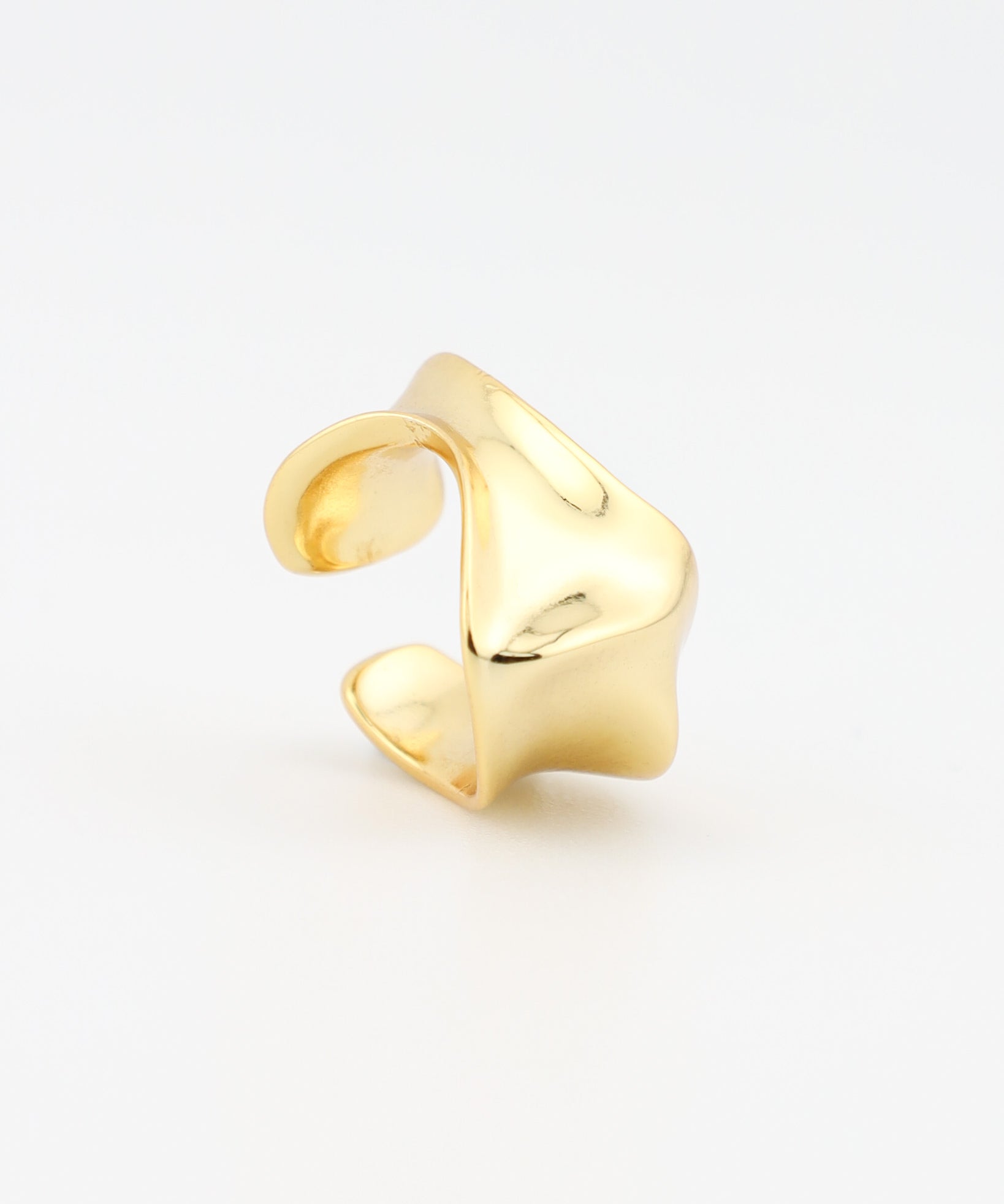 Gold ear cuff on a light gray background