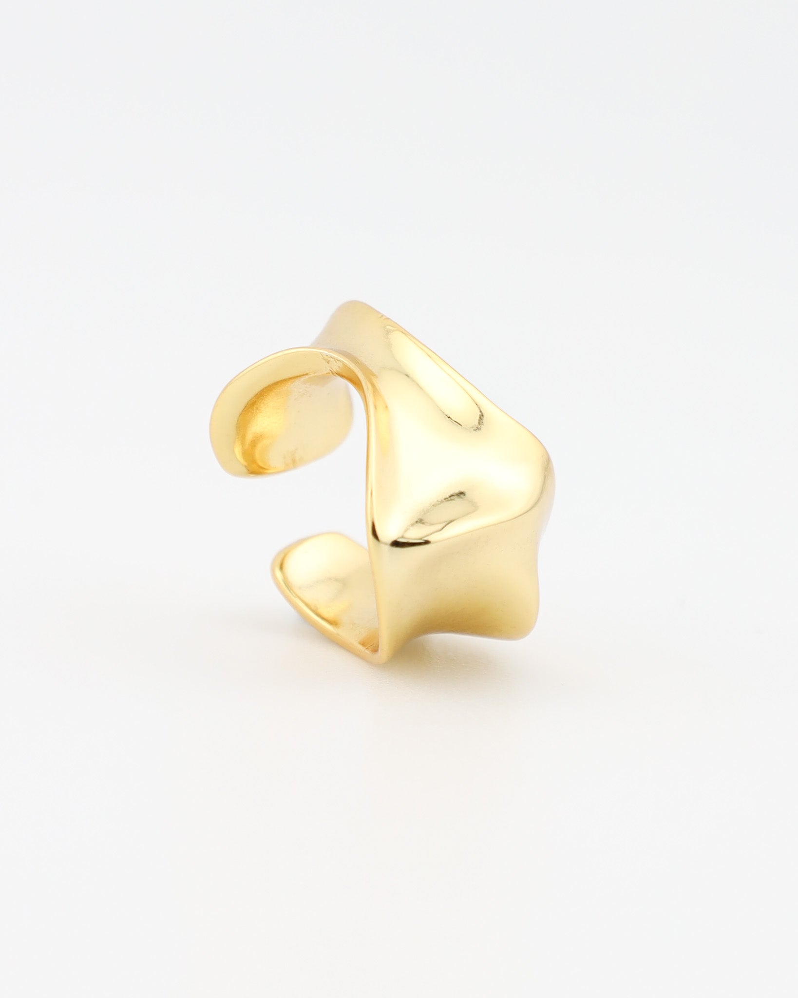 Gold ear cuff on a light gray background