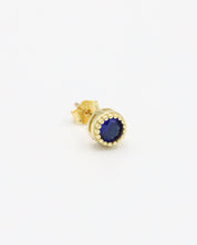 A single gold-colored stud earring with a blue stone and butterfly clasp closure on a white background.
