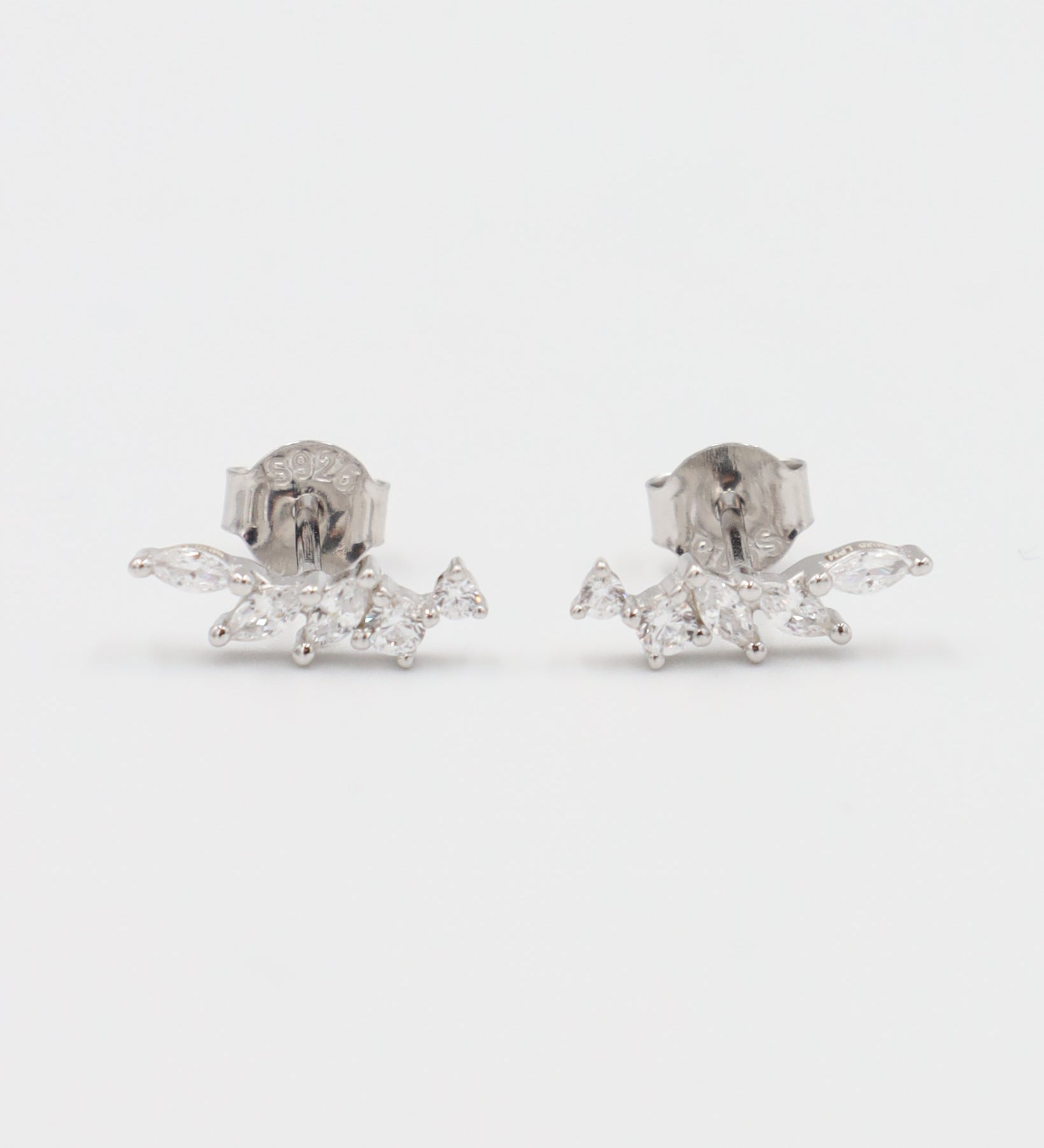A pair of silver stud earrings with a butterfly clasp, featuring a intricate pattern.