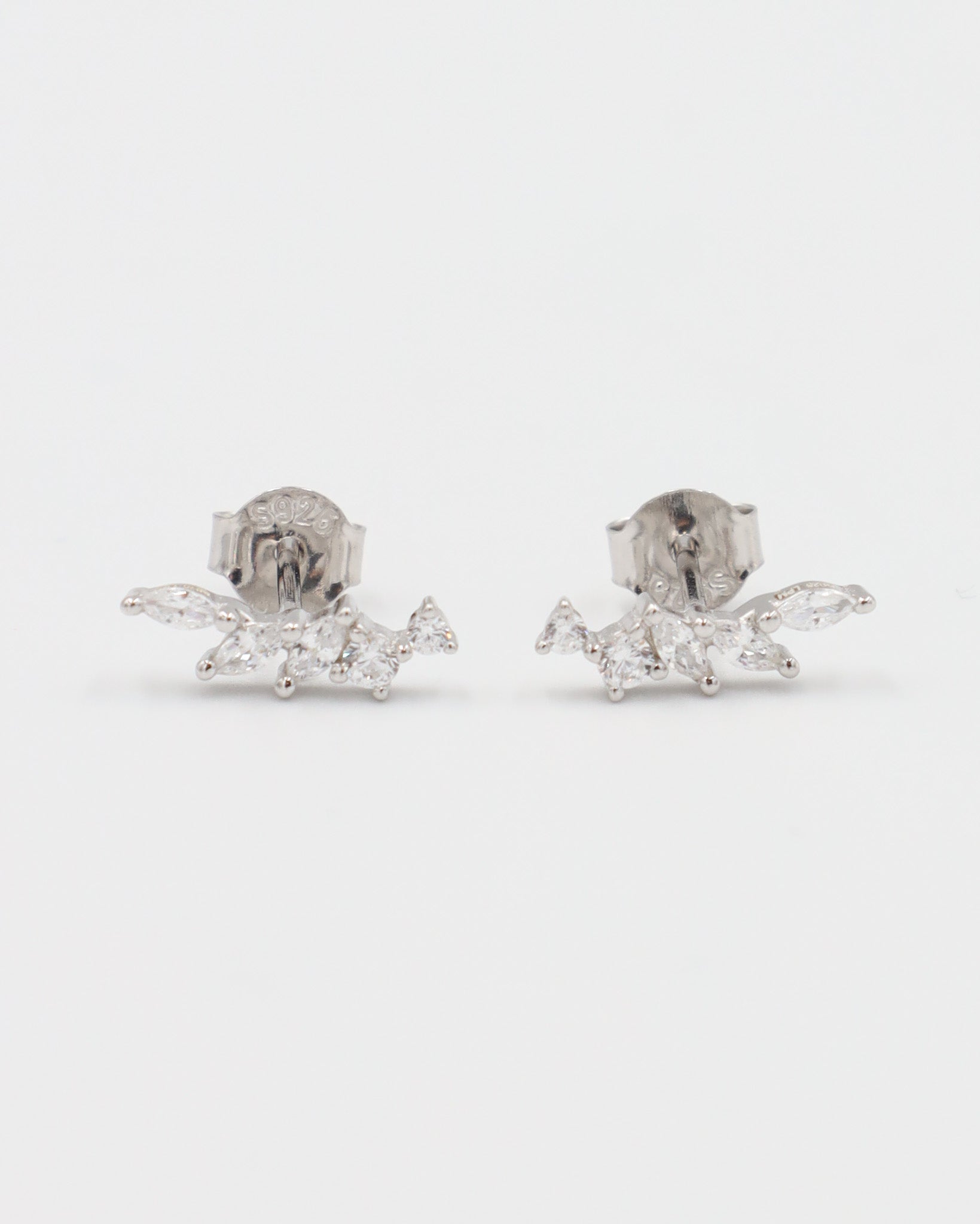 A pair of silver stud earrings with a butterfly clasp, featuring a intricate pattern.