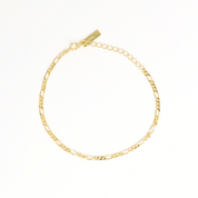 A gold-colored bracelet with a chain link design on a white background.