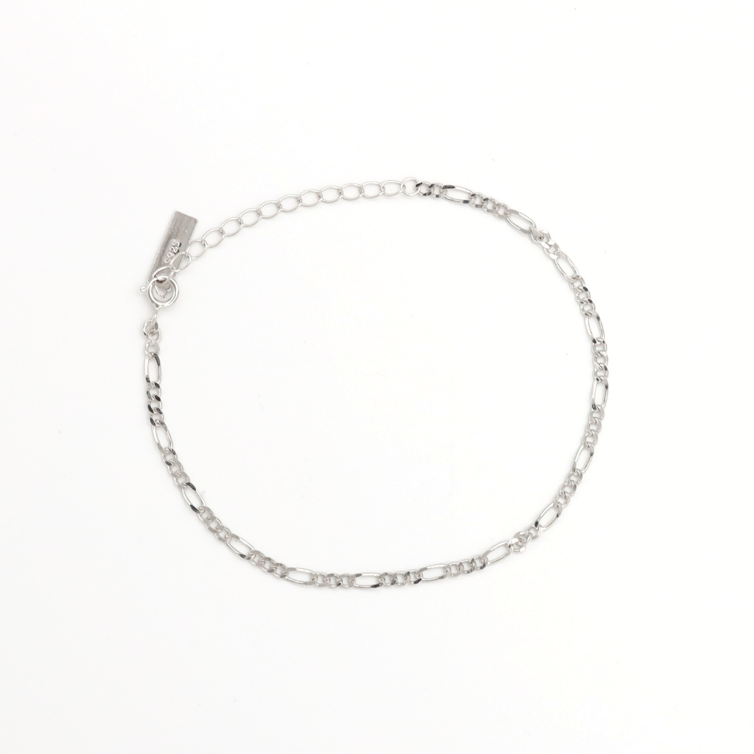 A silver bracelet with multiple interlinked chains laid out on a white background.