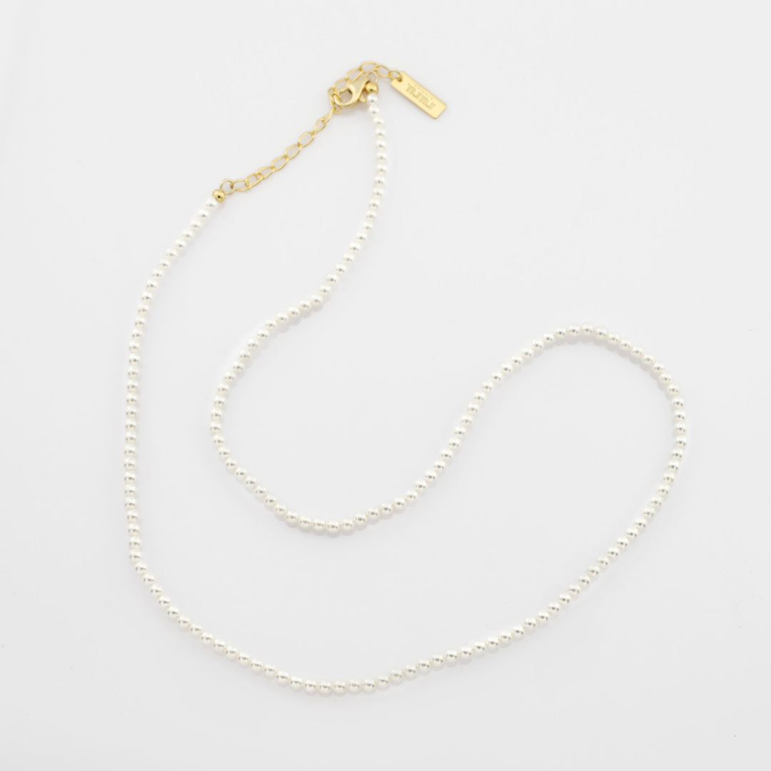 A pearl necklaces on a light gray background