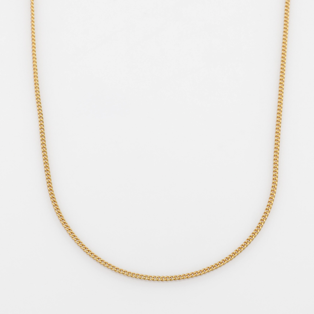 Gold minimalistic chain necklace on a white background